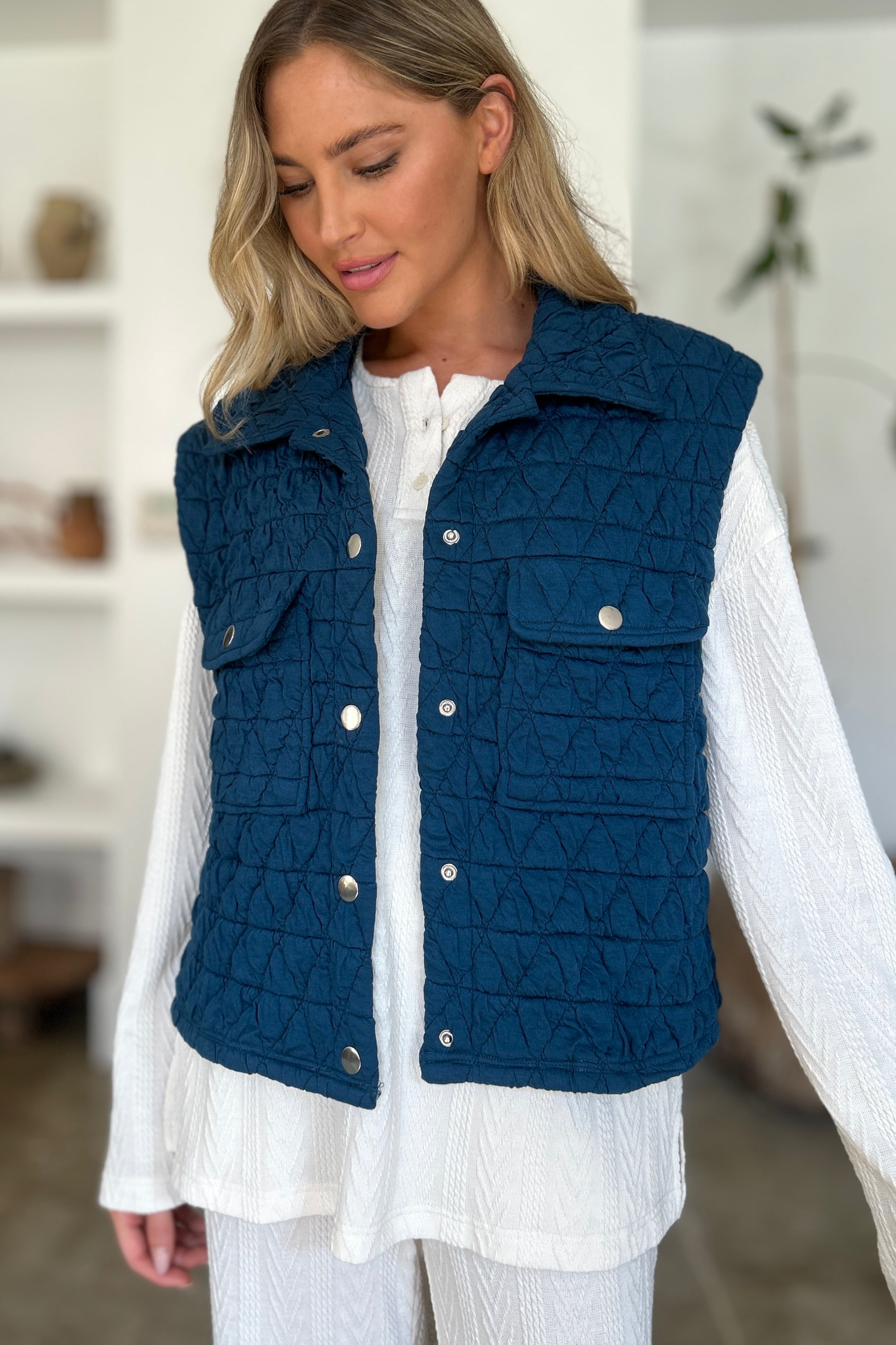 Back View of Quilted Textured Peacock Blue Vest with Button Snaps styled with white long sleeve shirt