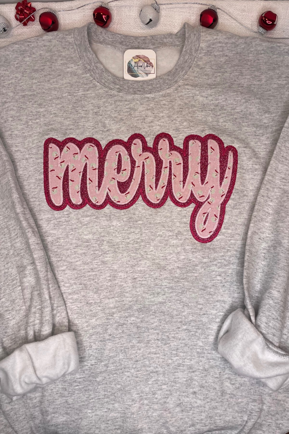 Merry sweatshirt on ash gray long sleeve Gildan with pink fabric and dark glitter background